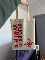 Beige Canvas Foldable Tote Bag with Red Spanish Text and All-Over Pattern